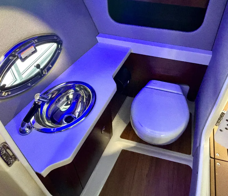 Slide: The Image of 2025 Chaparral 307 SSX boat bathroom with sink and toilet, featuring modern design. - 8