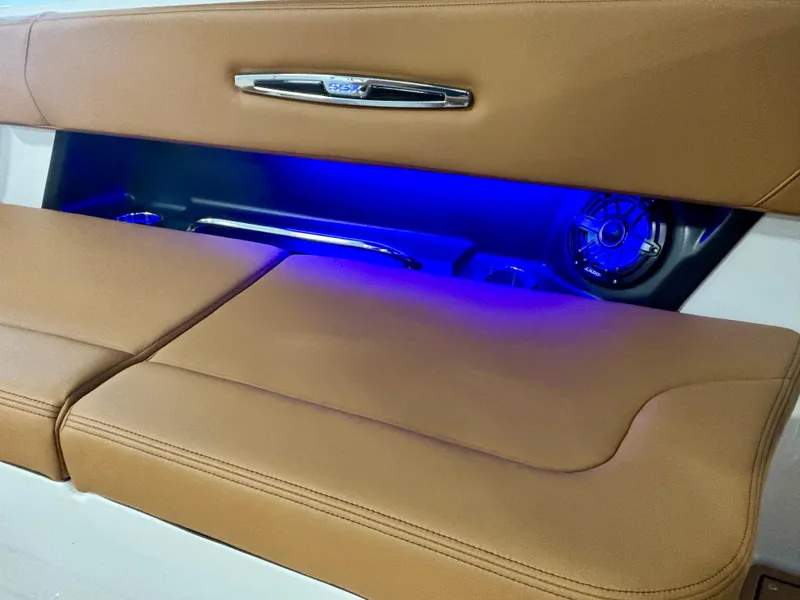 Slide: The Image of 2025 Chaparral 307 SSX boat interior with tan seating and blue LED lighting. - 9