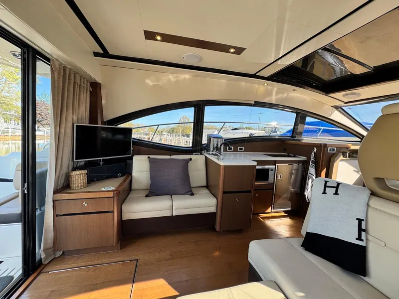 Slide: The Image of Interior of 2016 Sea Ray 400 Sundancer yacht with modern furnishings and large windows. - 10