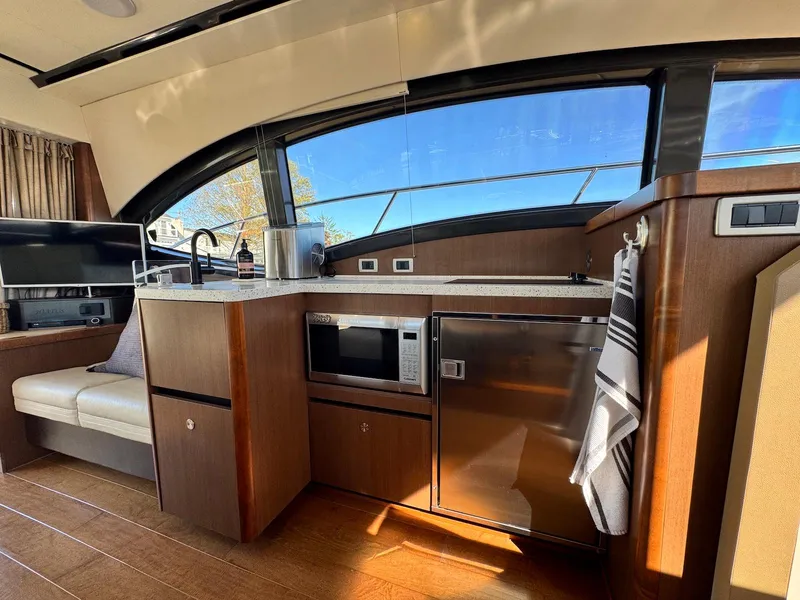 Slide: The Image of Interior of 2016 Sea Ray 400 Sundancer yacht with modern kitchen amenities. - 11
