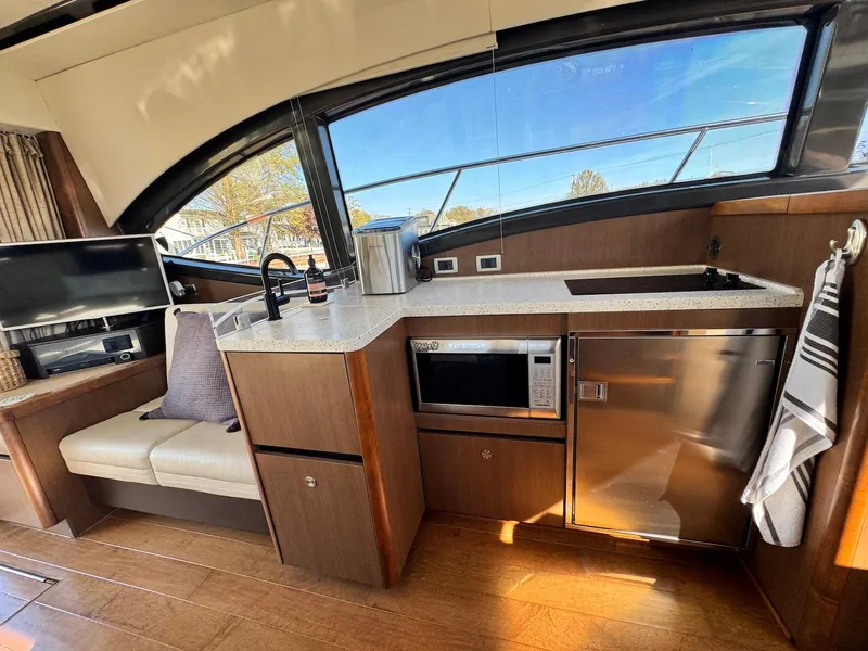 Slide: The Image of Interior of 2016 Sea Ray 400 Sundancer yacht with modern kitchen amenities. - 14