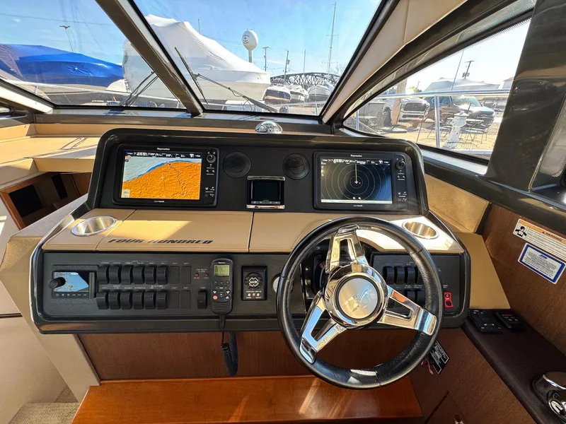 Slide: The Image of Helm of 2016 Sea Ray 400 Sundancer with navigation screens and steering wheel. - 17