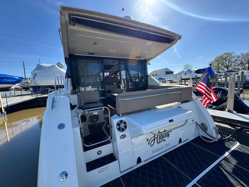 Slide: The Image of 2016 Sea Ray 400 Sundancer yacht docked, featuring spacious deck and American flag. - 2