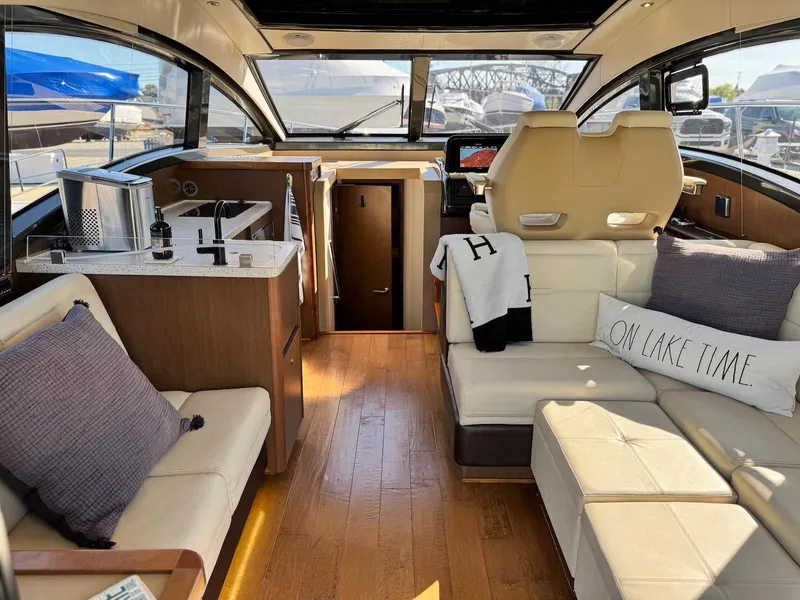 Slide: The Image of Luxurious interior of 2016 Sea Ray 400 Sundancer yacht with modern seating and wooden flooring. - 21