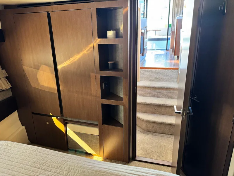 Slide: The Image of Interior of 2016 Sea Ray 400 Sundancer yacht, featuring wooden cabinetry and carpeted stairs. - 28