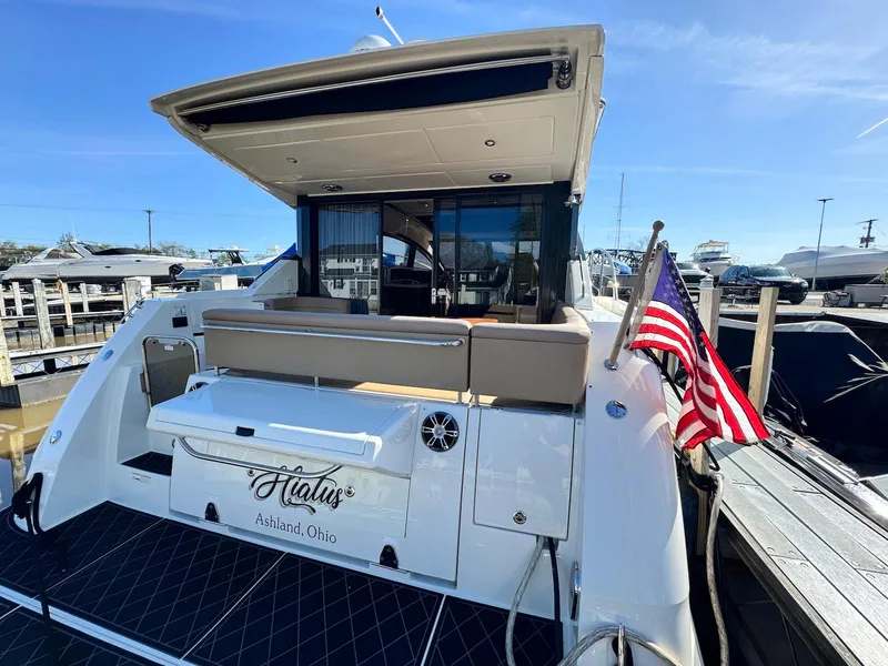 Slide: The Image of 2016 Sea Ray 400 Sundancer yacht docked, featuring a spacious deck and American flag. - 3