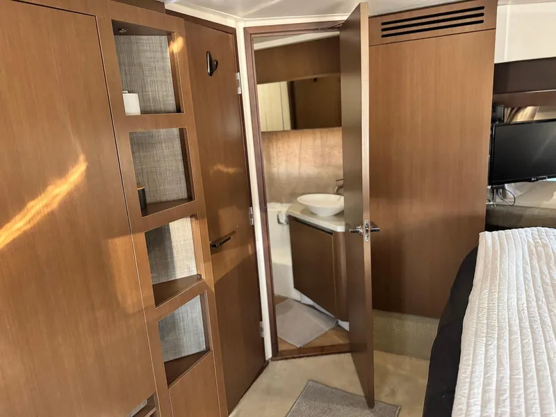 Slide: The Image of Interior of 2016 Sea Ray 400 Sundancer yacht, featuring wood cabinetry and a bathroom. - 30