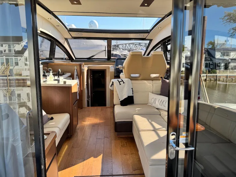 Slide: The Image of Luxurious interior of 2016 Sea Ray 400 Sundancer yacht with modern furnishings and panoramic windows. - 36