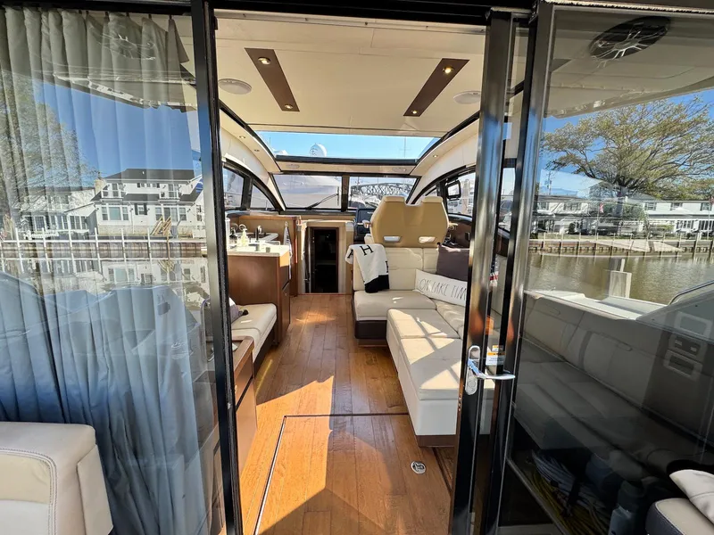 Slide: The Image of Interior view of 2016 Sea Ray 400 Sundancer yacht with luxurious seating and wooden flooring. - 37