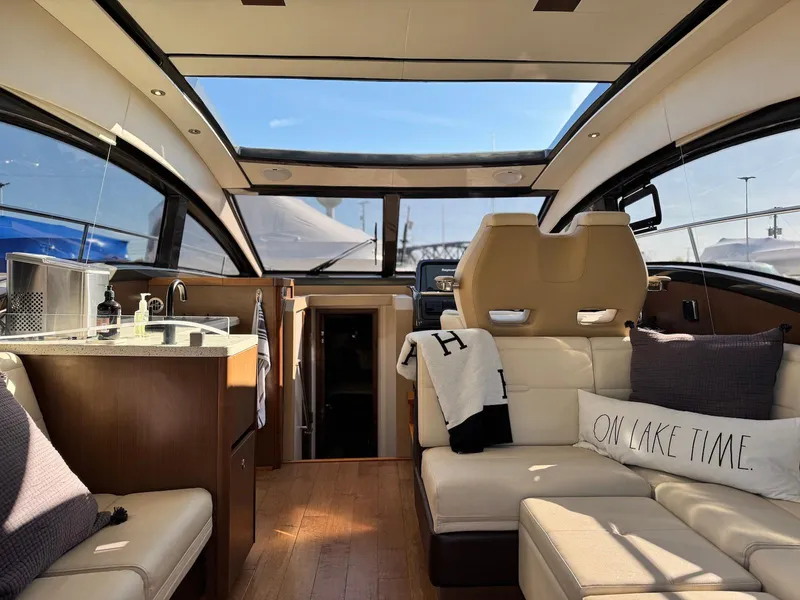 Slide: The Image of Interior of 2016 Sea Ray 400 Sundancer yacht with luxurious seating and panoramic windows. - 39