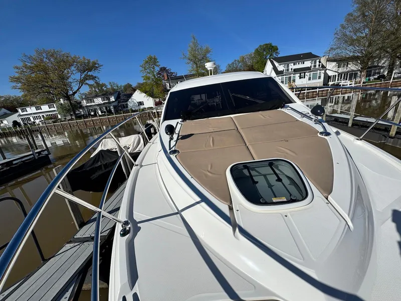 Slide: The Image of 2016 Sea Ray 400 Sundancer docked, showcasing sleek design and spacious deck. - 40