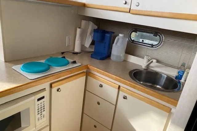 Slide: The Image of 1996 Cruisers Yachts 3650 Motoryacht kitchen with sink, microwave, and countertop essentials. - 11