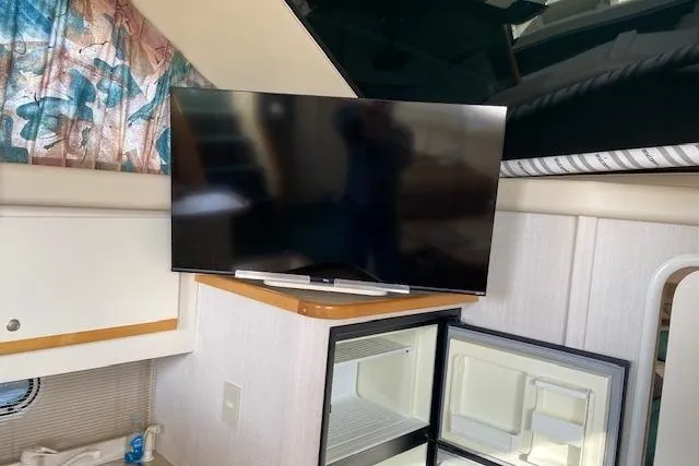 Slide: The Image of Interior of 1996 Cruisers Yachts 3650 Motoryacht with TV and open mini fridge. - 12