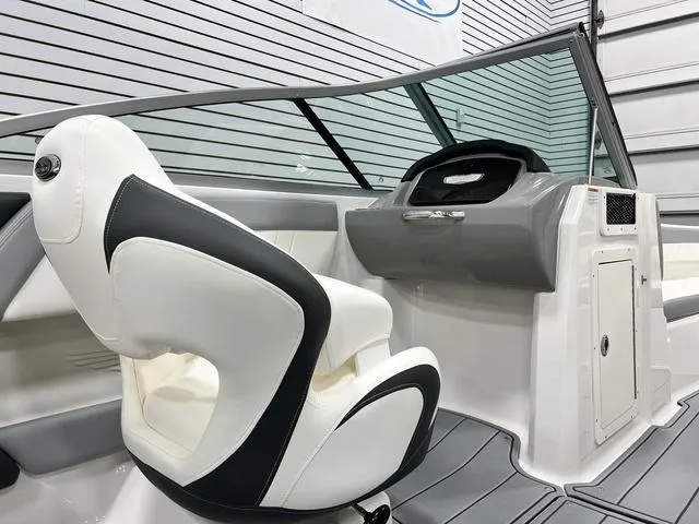Slide: The Image of 2024 Chaparral 21 SSi boat interior with sleek white and black seating, modern dashboard. - 10