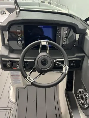 Slide: The Image of 2025 Chaparral 26 Surf boat dashboard with steering wheel and control panel. - 9