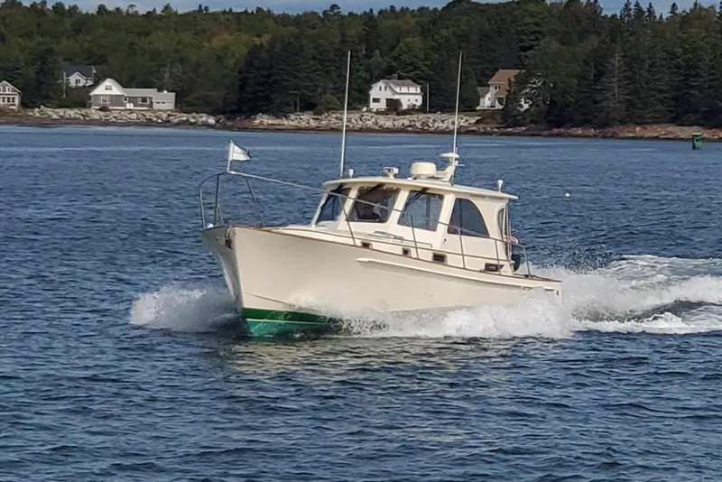 The Image of 2003 Legacy 40 Hardtop Express cruising on a scenic lake with houses in the background. - 0