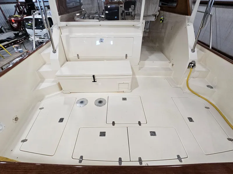 Slide: The Image of 2003 Legacy 40 Hardtop Express boat deck with storage compartments and seating area. - 15