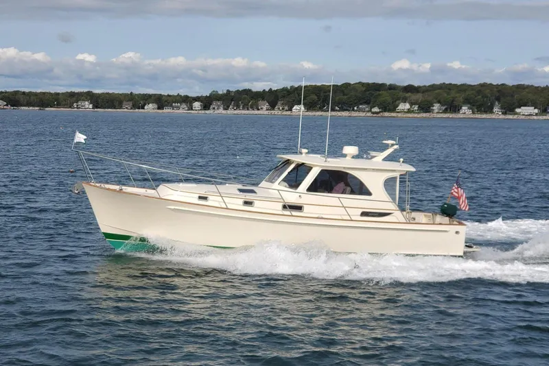 Slide: The Image of 2003 Legacy 40 Hardtop Express cruising on a scenic lake with shoreline houses. - 2