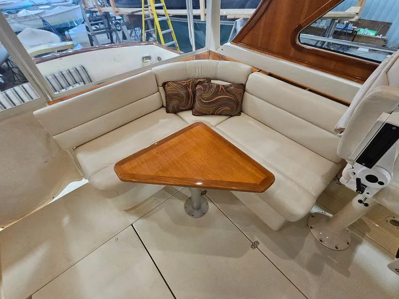 Slide: The Image of 2003 Legacy 40 Hardtop Express interior with cushioned seating and wooden table. - 20