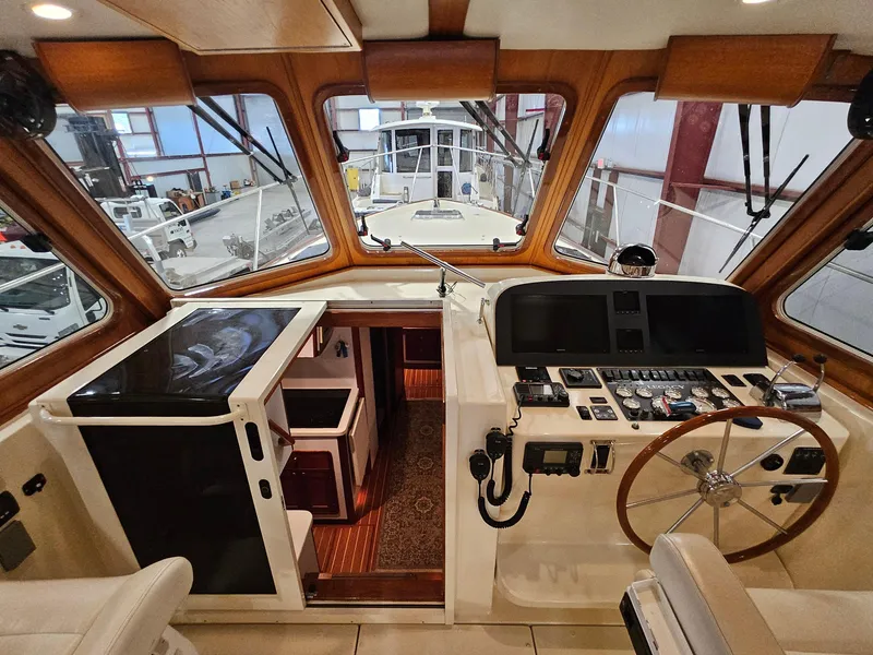 Slide: The Image of 2003 Legacy 40 Hardtop Express boat interior with navigation controls and wooden accents. - 25