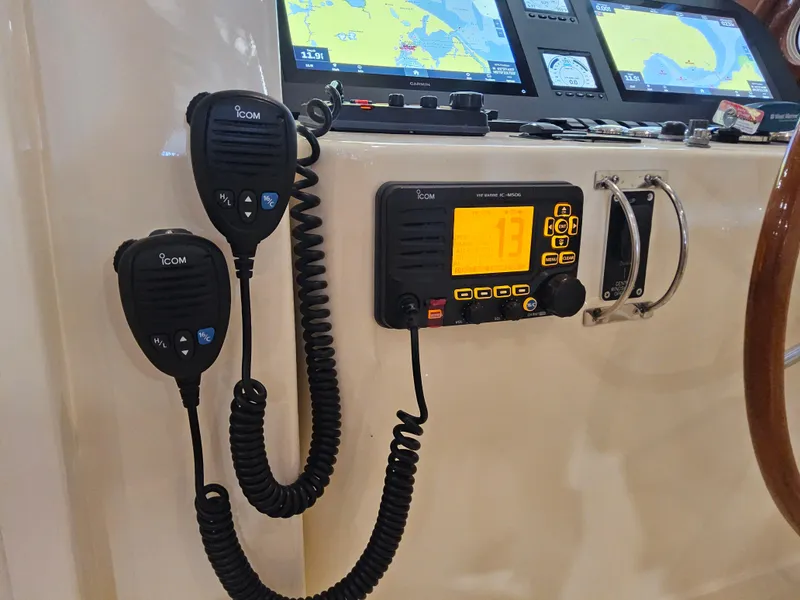 Slide: The Image of ICOM marine radio and microphones on a 2003 Legacy 40 Hardtop Express boat dashboard. - 29