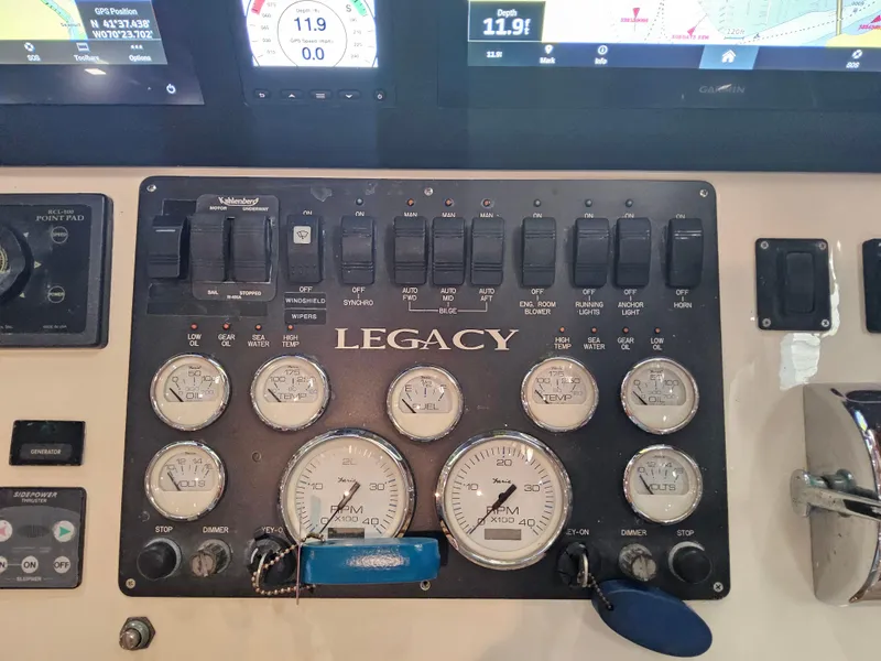 Slide: The Image of Control panel of a 2003 Legacy 40 Hardtop Express boat with gauges and switches. - 31