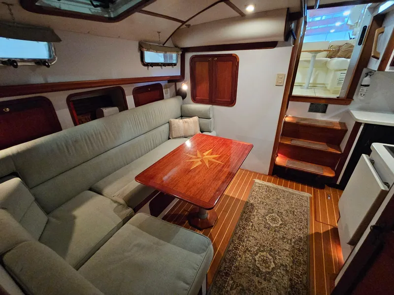 Slide: The Image of Interior of 2003 Legacy 40 Hardtop Express yacht with cozy seating and wooden table. - 40