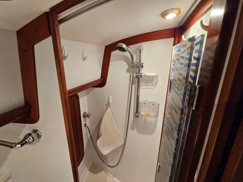 Slide: The Image of 2003 Legacy 40 Hardtop Express boat shower with wooden accents and modern fixtures. - 42