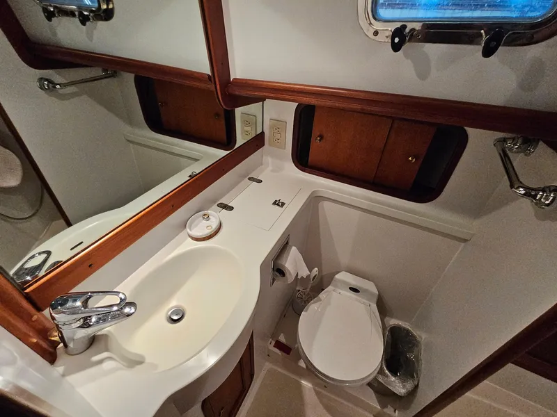 Slide: The Image of Bathroom interior of 2003 Legacy 40 Hardtop Express yacht, featuring sink and toilet. - 43