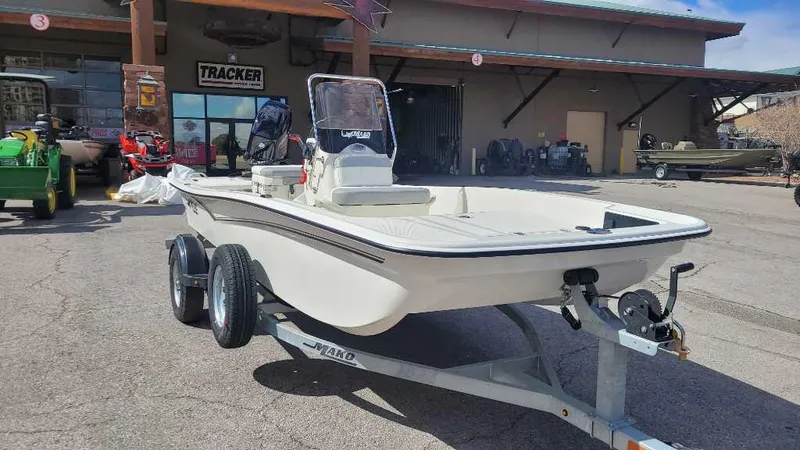 Slide: The Image of 2025 Mako Pro Skiff 15 CC boat on trailer, parked outside a dealership. - 4
