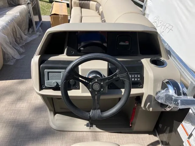 Slide: The Image of 2025 Sun Tracker Party Barge 20 DLX steering console with modern controls and beige seating. - 3