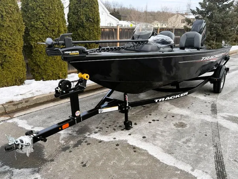 Slide: The Image of 2025 Tracker Super Guide V-16 SC boat on trailer, parked on snowy street. - 2
