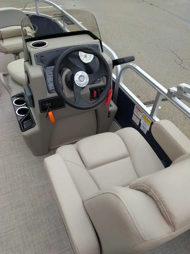 Slide: The Image of 2025 Sun Tracker Bass Buggy 16 XL Select boat interior with steering console and beige seating. - 2