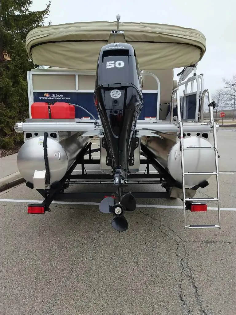 Slide: The Image of 2025 Sun Tracker Bass Buggy 16 XL Select pontoon boat with outboard motor and canopy. - 4