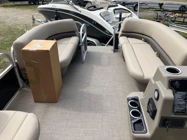 Slide: The Image of 2025 Sun Tracker Party Barge 16 DLX with beige seating and a box on deck. - 2