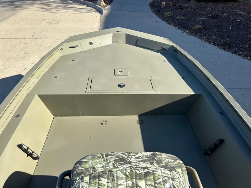 Slide: The Image of 2025 Tracker Grizzly 1860 CC boat interior with camouflage seat, spacious deck, and storage compartment. - 3