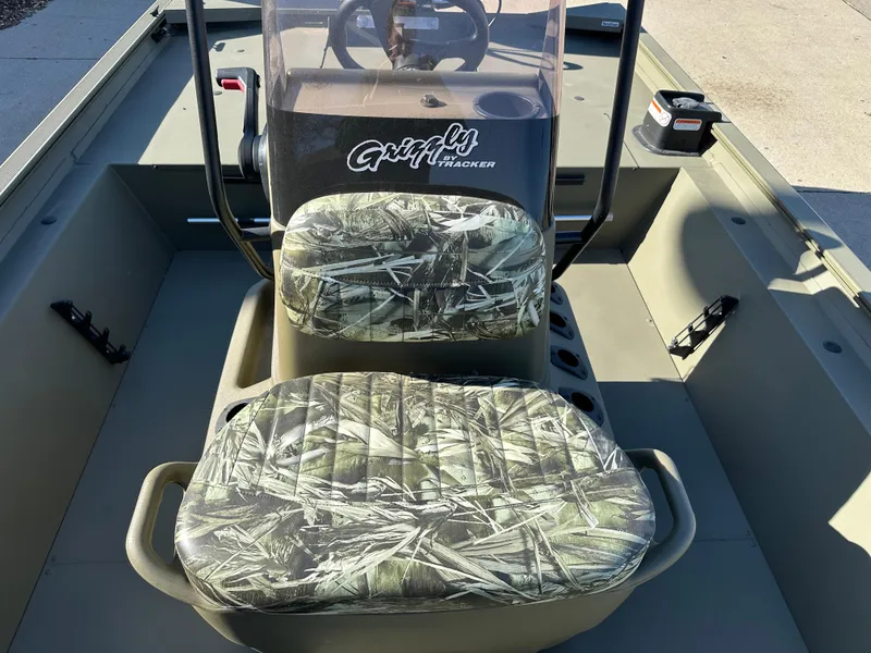 Slide: The Image of 2025 Tracker Grizzly 1860 CC boat interior with camo seats and steering console. - 4