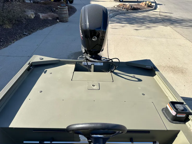 Slide: The Image of 2025 Tracker Grizzly 1860 CC boat with outboard motor on pavement. - 6