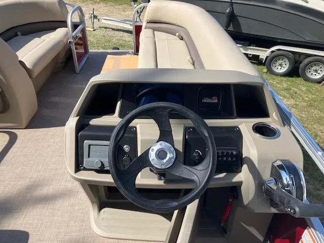 Slide: The Image of 2025 Sun Tracker Party Barge 18 DLX steering console with comfortable seating and modern controls. - 2