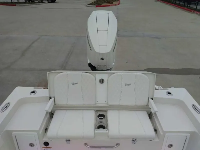 Slide: The Image of 2025 Ranger 2660 Bay boat with white seating and motor, docked on concrete. - 11