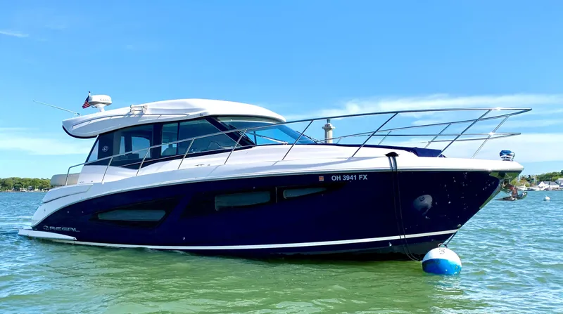 Slide: The Image of 2018 Regal 42 Grande Coupe yacht on water under clear blue sky. - 0