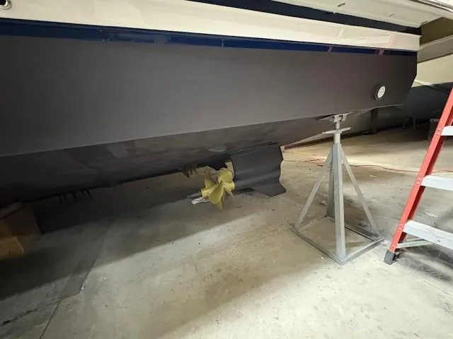 Slide: The Image of 2018 Regal 42 Grande Coupe boat hull in dry dock, supported by a metal stand. - 23
