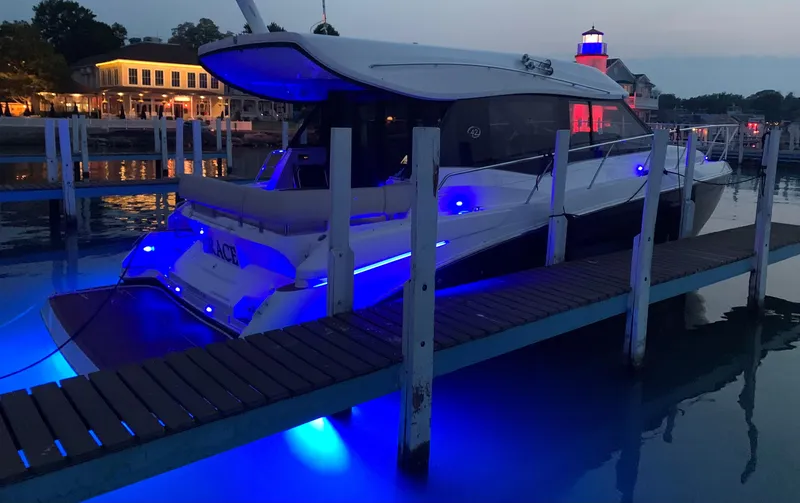 Slide: The Image of 2018 Regal 42 Grande Coupe yacht docked with blue LED lights at dusk. - 4