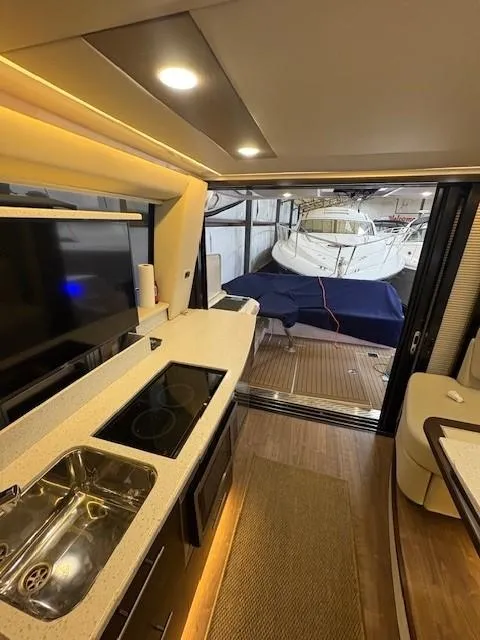 Slide: The Image of Interior view of 2018 Regal 42 Grande Coupe yacht with modern kitchen and outdoor deck. - 9
