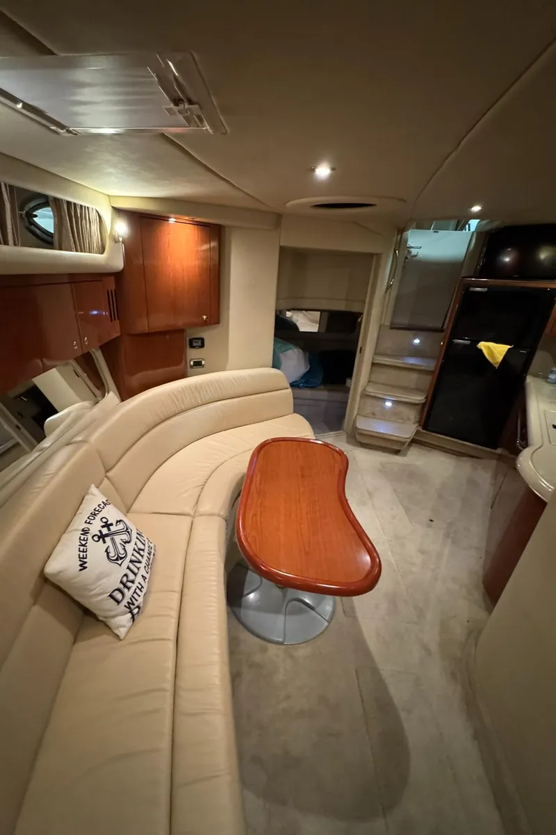 Slide: The Image of Interior of a 2002 Sea Ray 410 Sundancer yacht with beige seating and wooden table. - 13