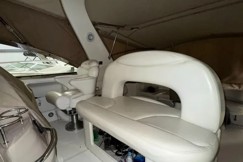 Slide: The Image of 2002 Sea Ray 410 Sundancer interior with white leather seating and helm station. - 14