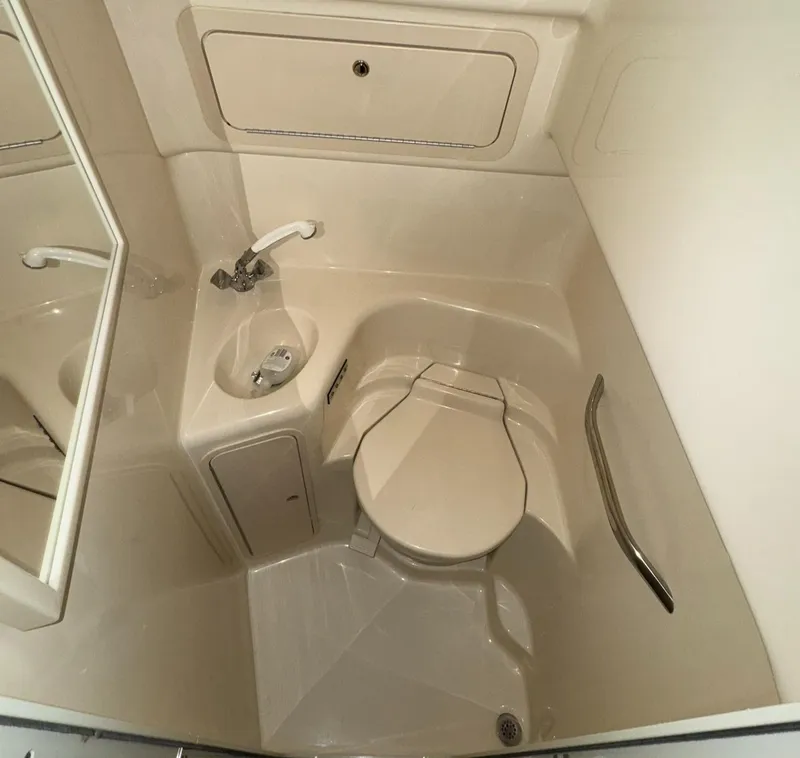 Slide: The Image of 2002 Sea Ray 410 Sundancer bathroom with sink, toilet, and storage cabinet. - 16