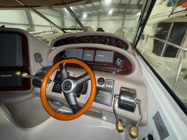 Slide: The Image of Cockpit of 2002 Sea Ray 410 Sundancer with wooden steering wheel and control panel. - 18