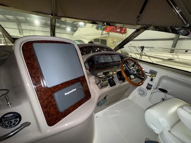 Slide: The Image of 2002 Sea Ray 410 Sundancer helm with modern navigation equipment and luxurious seating. - 19