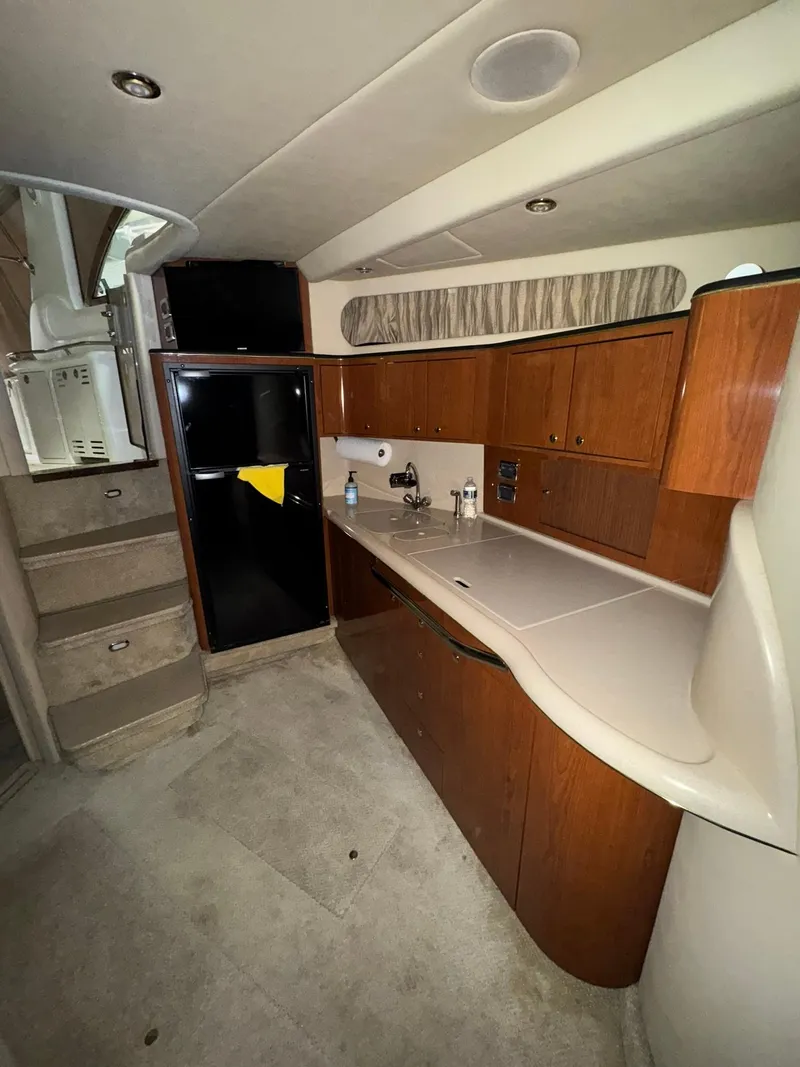 Slide: The Image of Interior of 2002 Sea Ray 410 Sundancer yacht with modern kitchen amenities. - 4